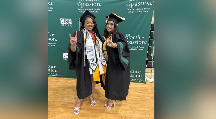 two graduates smiling