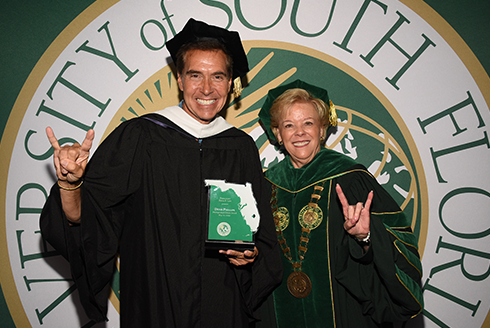 USF President Rhea Law gives the go bulls hand signal at commencement