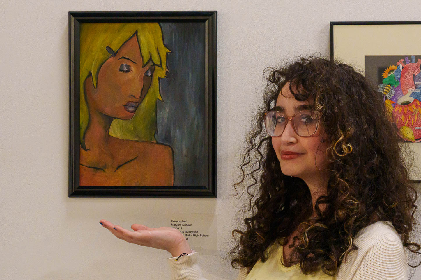 Student Maryam Alsharif shows off her piece "Despondent" in the Carolyn M. Wilson Gallery.