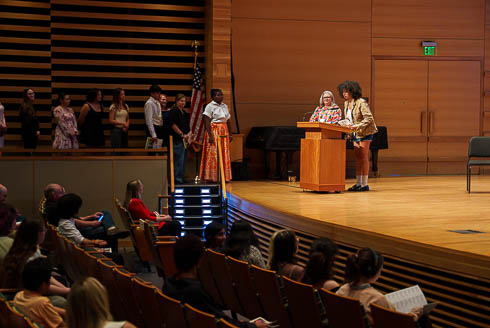 A student speaks about their work while Laura Hobby, Supervisor of Visual and Theatre Arts Education for Hillsborough County Public Schools, looks on.