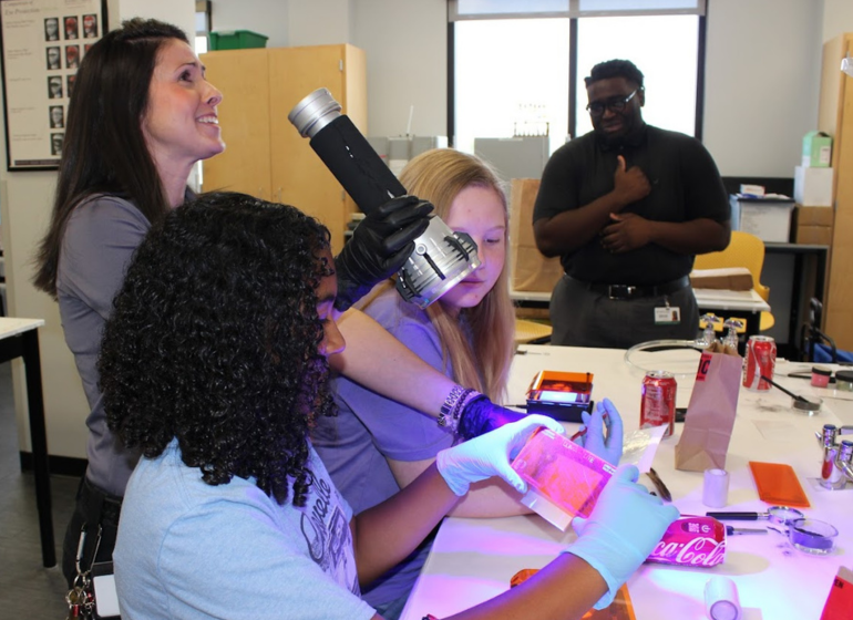 Students examine crime scene with tools