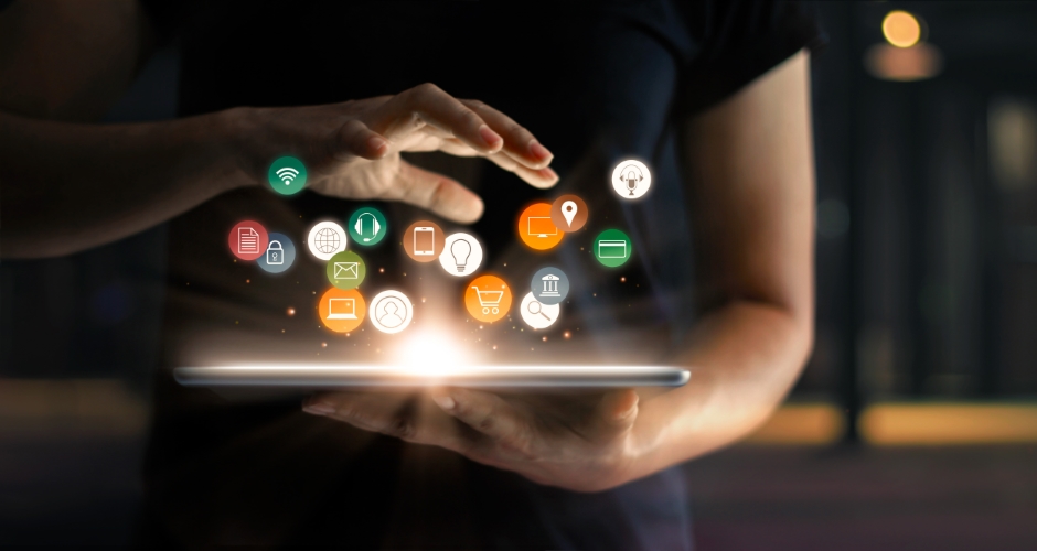 Social media icons lifting off of a tablet by a person's hands