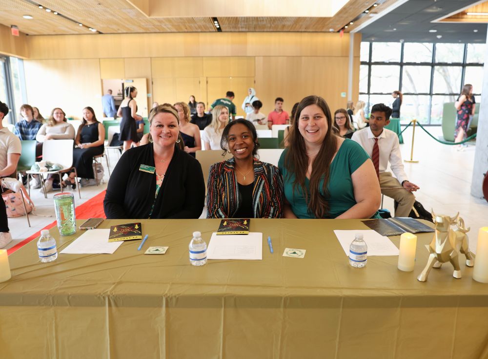 Lauren Chambers, Anrae Stephenson, and Megan Braunstein preparing their votes at one of the judges' tables.