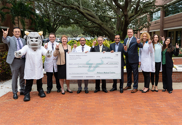 USF faculty and administrators receiving a $1 million check from Reliance Medical Centers 