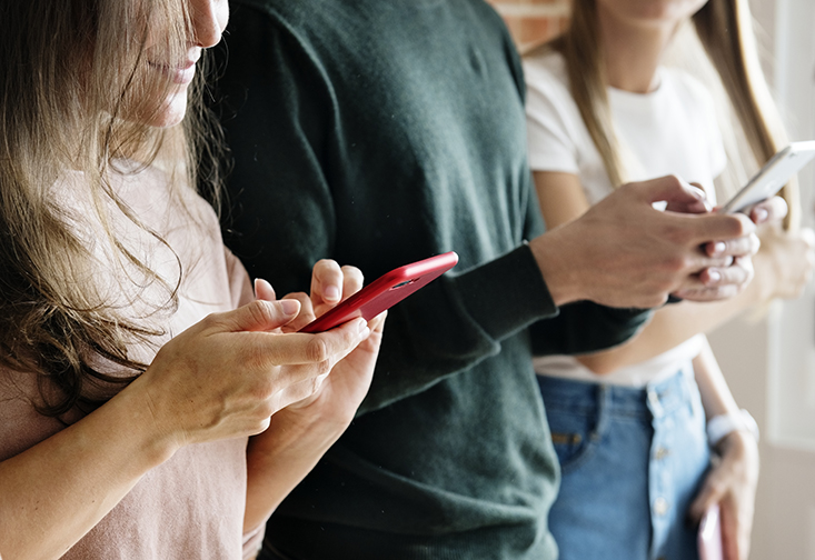 A stock image of people using their cell phones