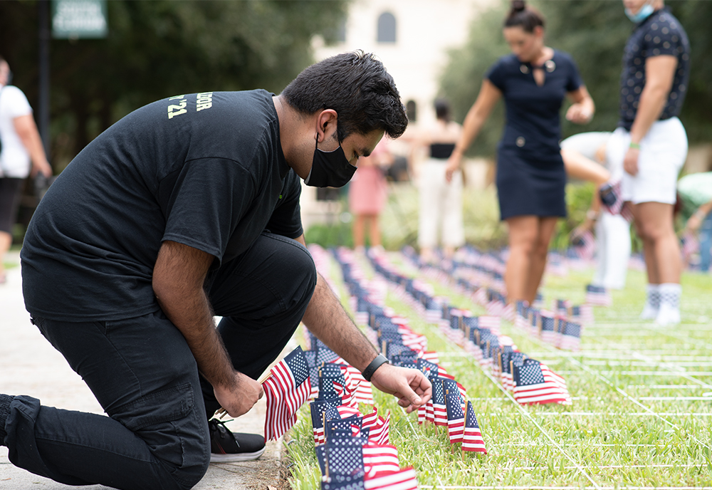 Riffatul Islam, USF Sarasota-Manatee campus governor, helps place 2,977 flags across the campus courtyard in honor of each of the lives lost on 9/11..