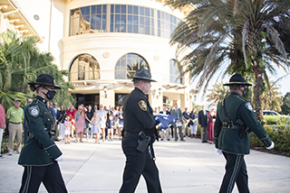 Officers walking with an American flag at the Sarasota-Manatee campus event